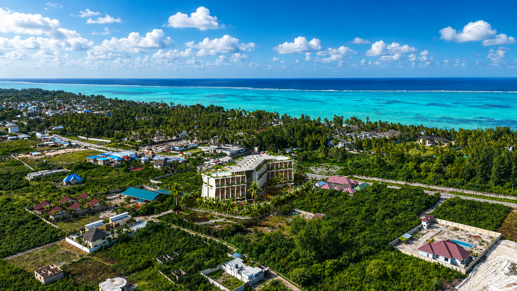 Aerial render of ANGA Zanzibar showing two building stacks, rooftop pools and Paje beach beyond